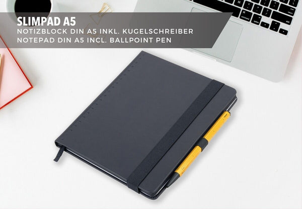 Black Troika notebook with yellow pen on a white surface, with text about Slimpad A5 notepad and ballpoint pen.
