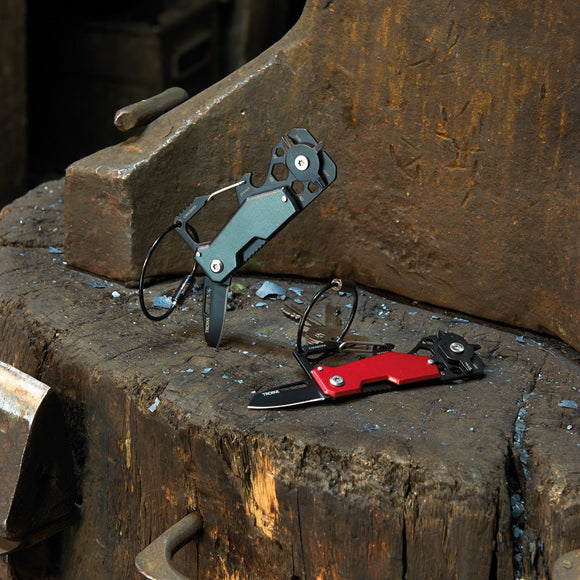 Troika Toolinator pocket multi-tool shown in red and titanium on block of wood.