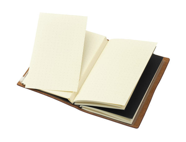 Open TROIKA travel notebook with cream pages on a white background