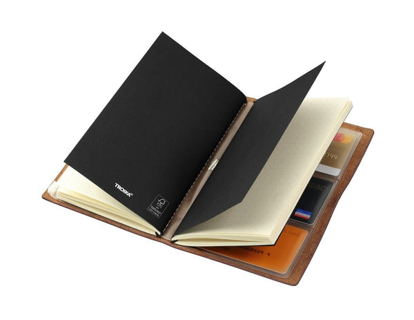 Open TROIKA notebook with black and beige pages on a white background